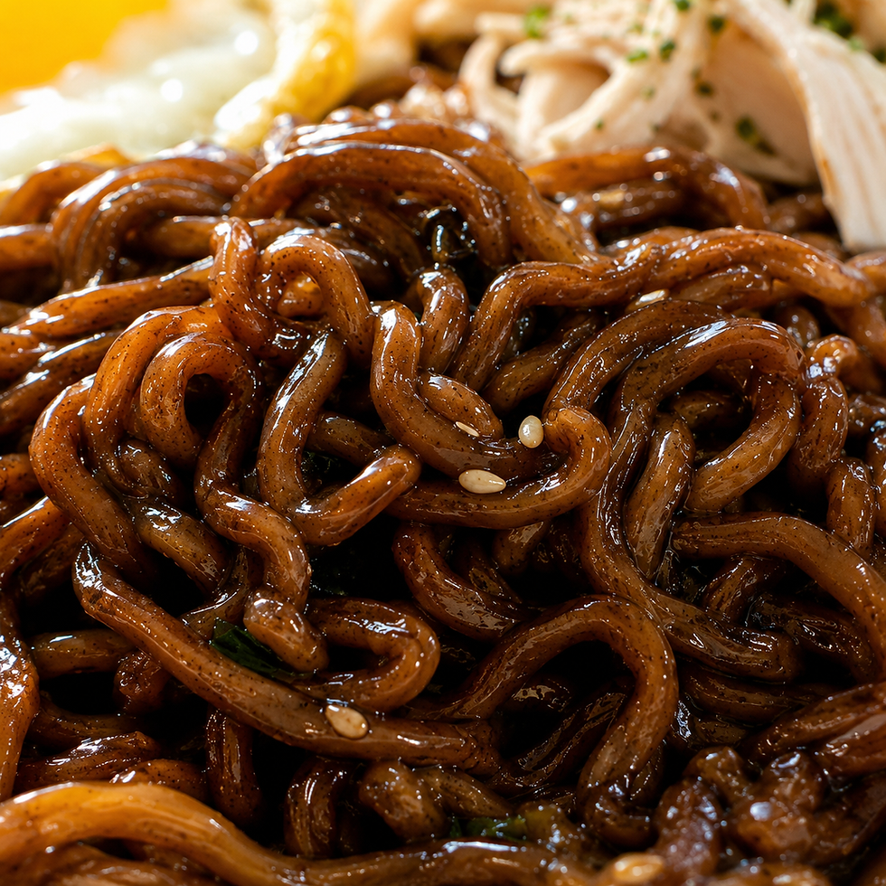 Ultra-macro close-up of glossy black-brown jajang ramen noodles coated in thick sauce. The image emphasizes the chewy curly noodle texture, shiny sauce cling, tiny seasoning specks, sesame seeds, and soft blurred toppings in the background.