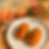 Two orange carrot breads sit on a white plate beside the Premium Carrot Bread package on a sunlit wooden table.
