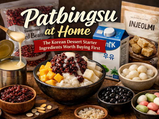 Premium blog thumbnail for “Patbingsu at Home: The Korean Dessert Starter Ingredients Worth Buying First,” featuring a large bowl of Korean shaved ice topped with sweet red beans, condensed milk, mango, and rice cake pieces, surrounded by starter ingredients like red bean paste, milk, injeolmi powder, mochi balls, and colorful rice cakes on a warm wooden tabletop.