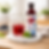 Bottle of Korean Hongcho blueberry drinking vinegar beside a glass of red iced drink with mint on a round marble board in a bright modern kitchen setting.