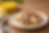 Close-up of chunky canned tuna piled on a bright yellow plate set on a larger orange plate, with a yellow tuna can blurred in the background on a beige surface.