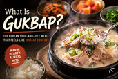 Blog thumbnail showing steaming gukbap in a black stone bowl with milky broth, sliced pork, green onions, and a spoonful of rice, with bold title text and side dishes in the background.