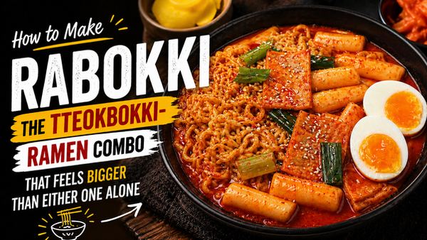 Landscape blog thumbnail showing spicy Korean rabokki in a black bowl with ramen noodles, rice cakes, fish cakes, scallions, sesame seeds, and soft-boiled eggs beside bold “Rabokki” title text.