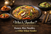 Thumbnail for a Japchae article featuring one plate of glossy Korean glass noodles with beef and vegetables, surrounded by small Korean side dishes and centered title text.