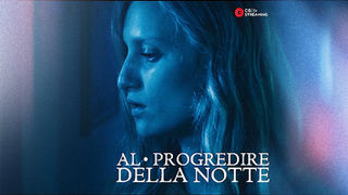 Scena del film horror “Al progredire della notte” su CG tv: donna bionda in primo piano, illuminata da luce blu, con espressione inquieta.