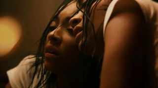 Corto “Mia”: giovane donna con treccine si appoggia con il viso a uno specchio, in un’atmosfera intensa e drammatica.