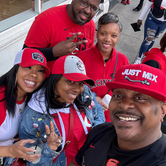 Group selfie during Cincinnati Reds Opening Day 2026 with friends wearing red Cincinnati Reds gear while celebrating downtown Cincinnati during the parade and block party festivities.