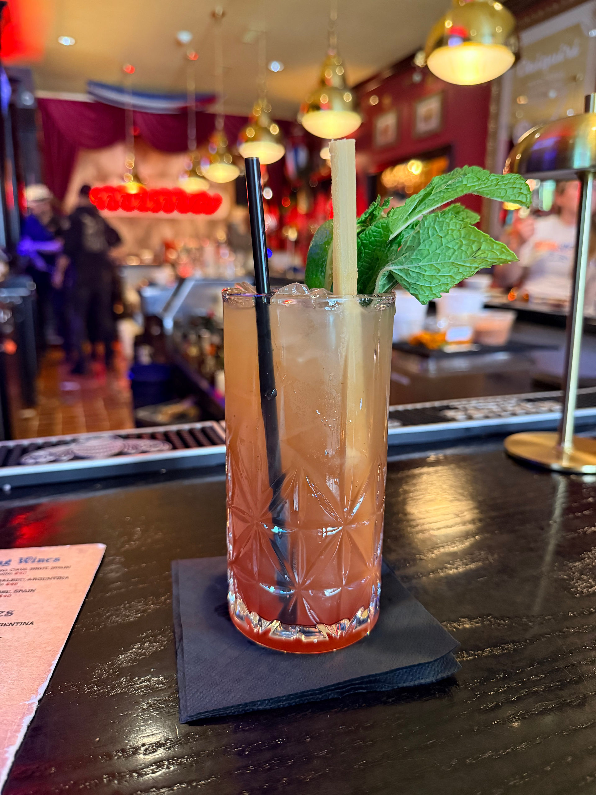 Craft cocktail garnished with fresh mint and sugarcane on a bar at La Bodeguita Cuban Restaurant in Louisville Kentucky