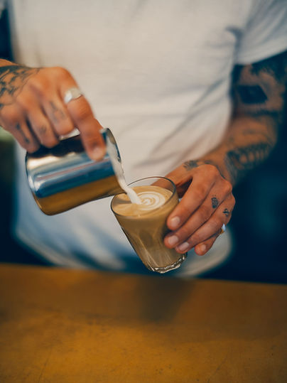 Barista som häller upp en latte