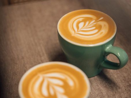  flat white coffee with latte art in a green mug