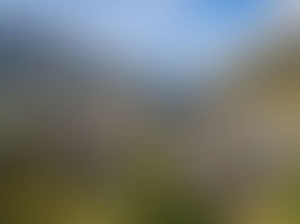 Panoramablick auf Andermatt im Urserntal mit Dorfzentrum, Kirche und Alpenbergen bei Sonnenschein