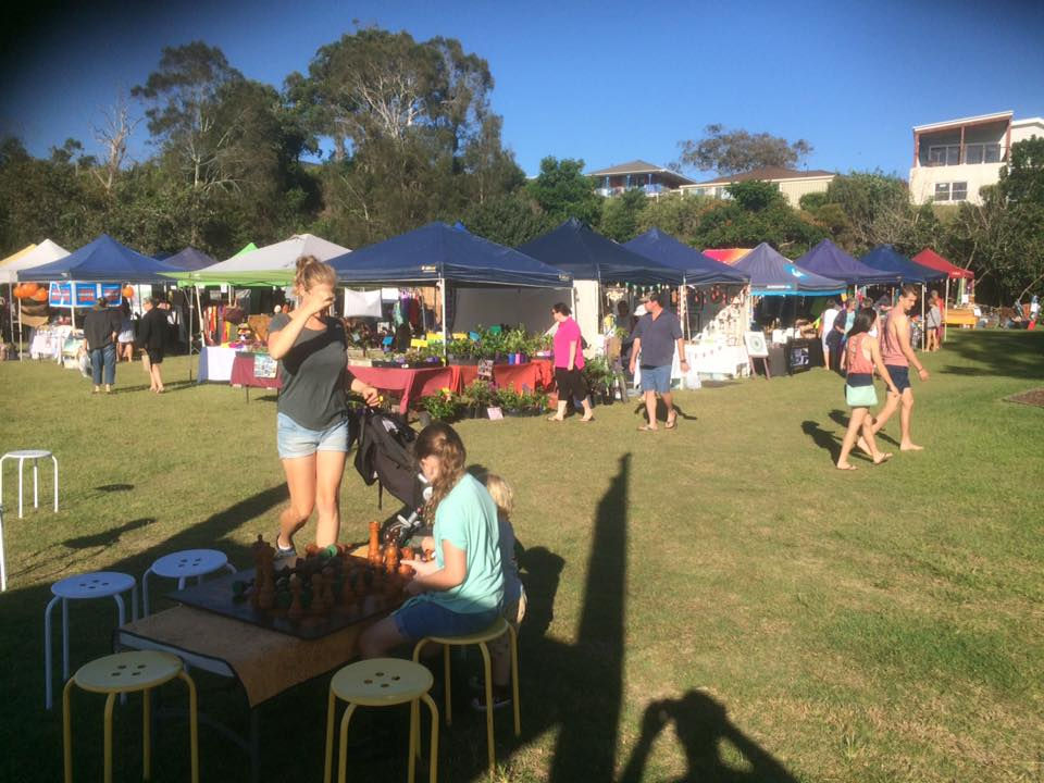 a group of people are gathered in a field at a market