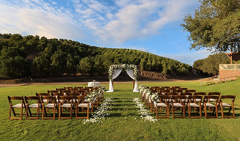 Rustic outdoor wedding ceremony setup at Sunmist Estate with dark wood chairs, white flower petals on the aisle