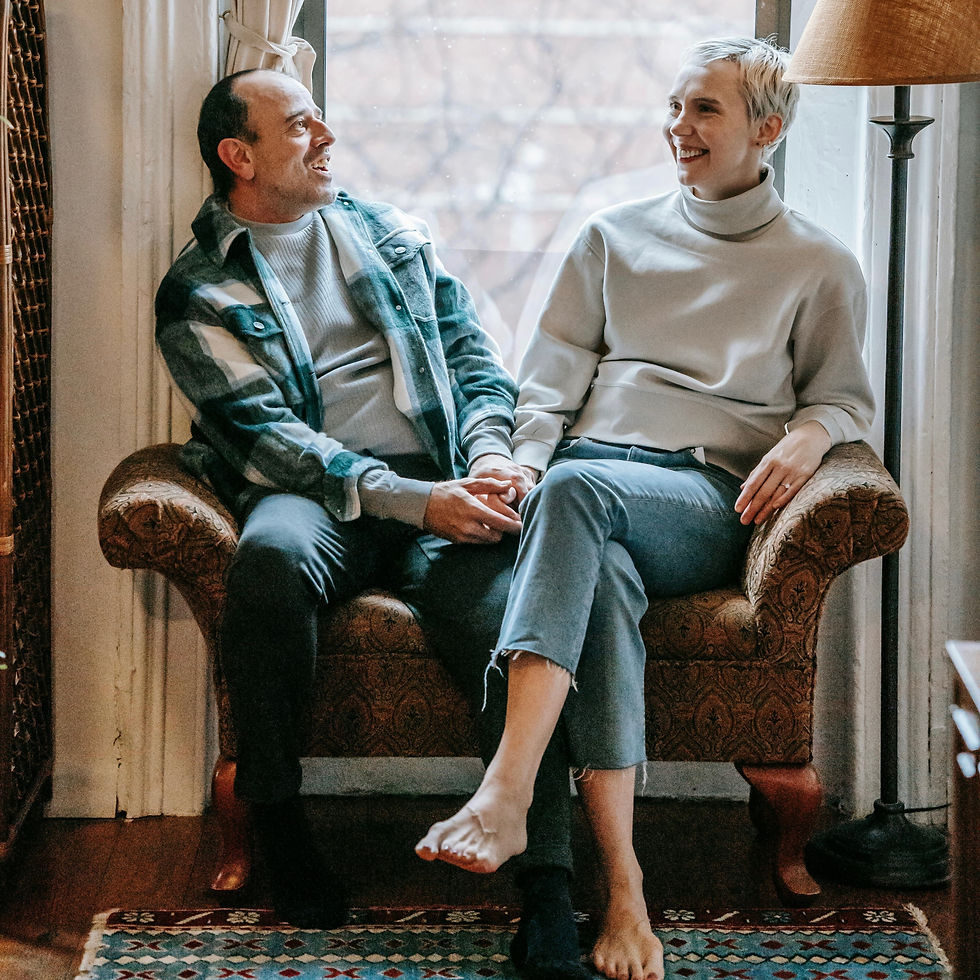 A mature pair seated closely together in an armchair