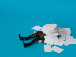 A person buried under a pile of documents