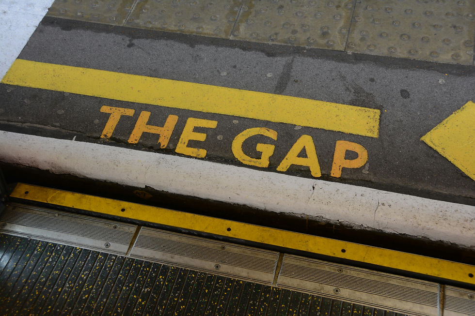 Yellow ‘Mind the Gap’ warning painted on a train platform edge, symbolizing the communication gap between leaders and teams.