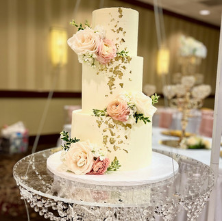 Elegant wedding cake with gold leaf and natural flowers