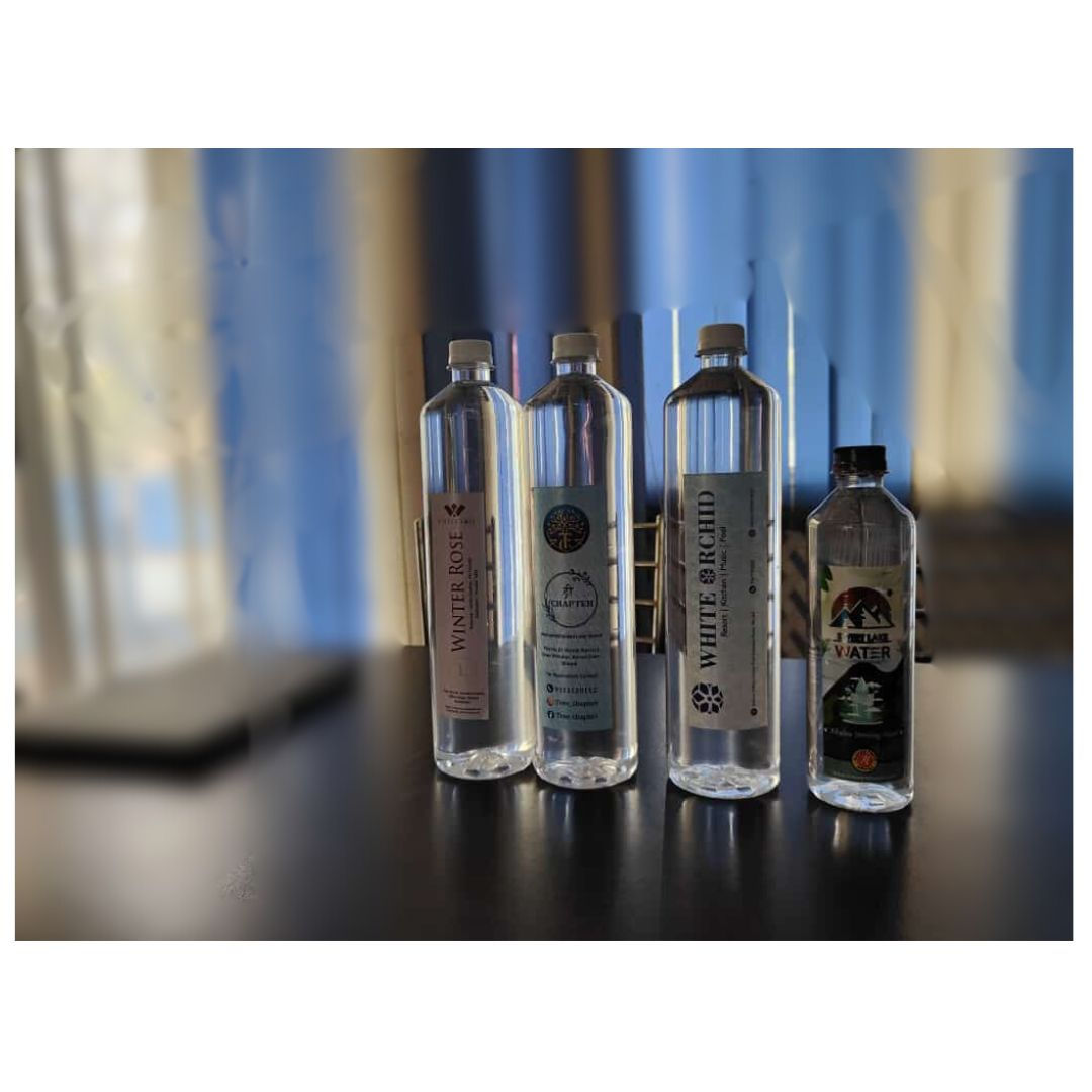 Four Black Gold PH 10.0 water bottles on a dark surface.