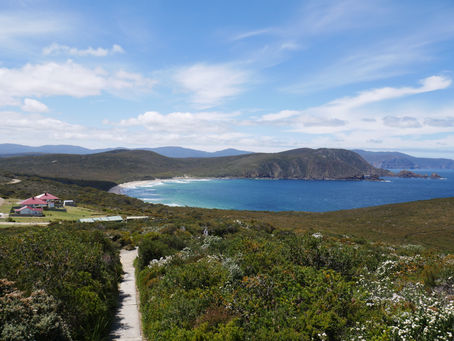 Coastal bay with blue ocean and sky amongst rolling hills