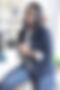 Dr. Terainer Brown sitting on a stool and smiling