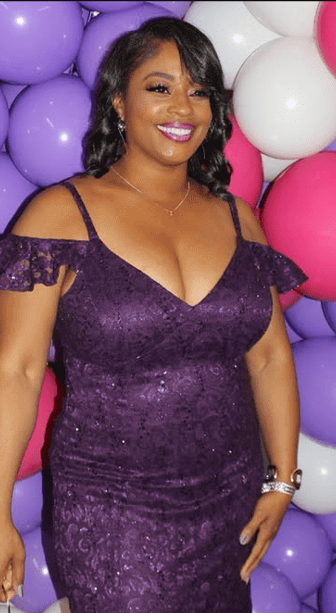 Clara Throckmorton smiling in a purple lace dress in front of a backdrop of pink, white, and purple balloons