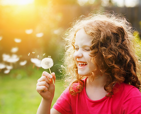little-curly-girl-blowing-dandelion-laug