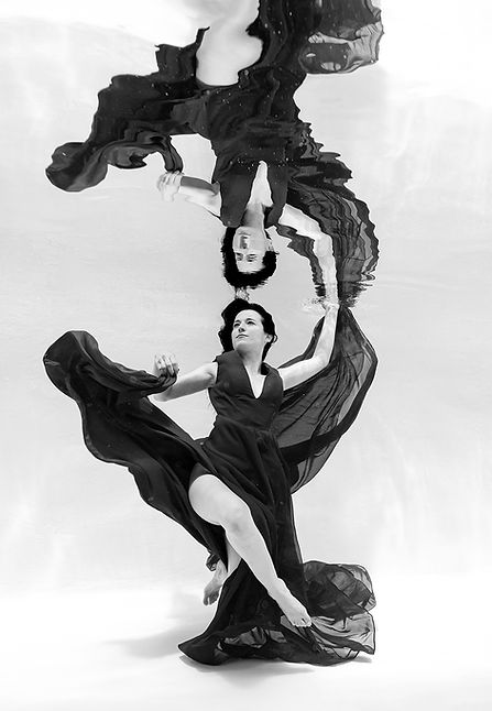 Photo aquatique d'une femme en noir et blanc et son reflet