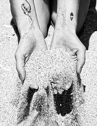 Deux mains sur la plage avec du sable qui s'écoule