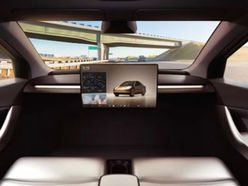 Driverless car with no steering wheel, speeding down the highway.