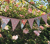 Waterproof bunting comprising of alternate pink and white spotty and blue and pink floral flags