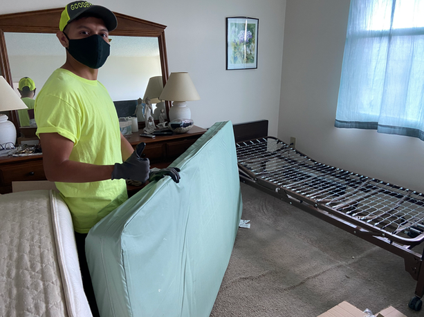 hospital bed mattress and frame being removed from an apartment.