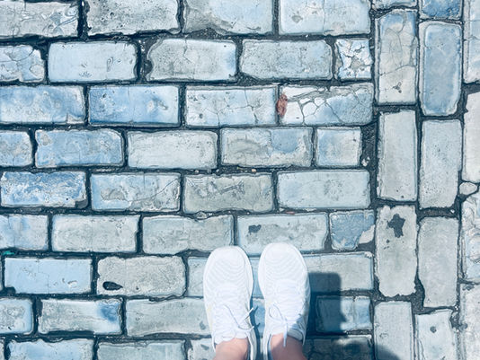 Teacher walkin gon uneven cobblestone street in Old San Juan, illustrating learning foundations.