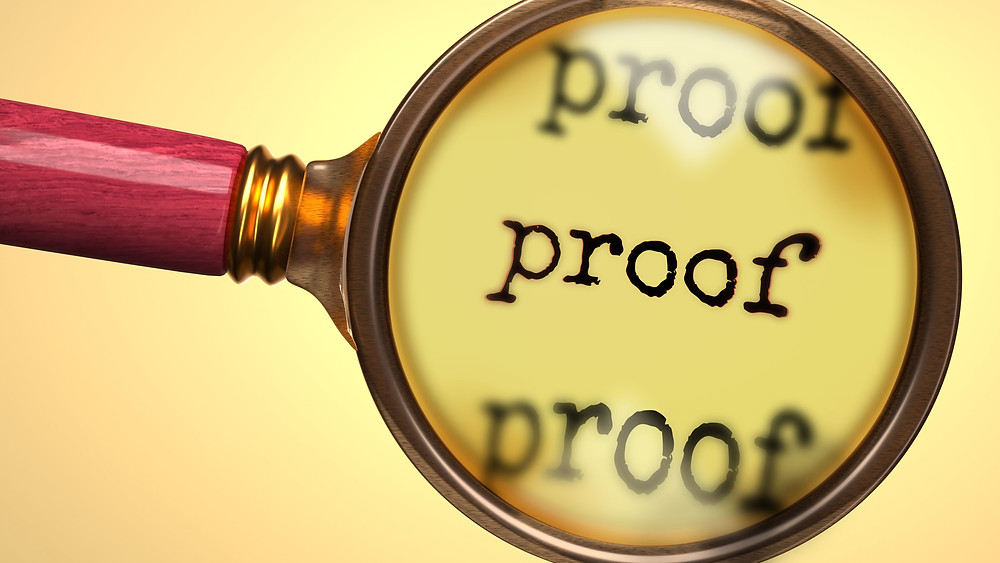 Magnifying glass hovering over the word proof on a manuscript
