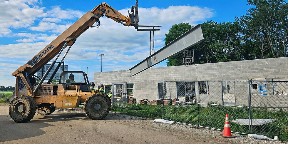 Telehandler lifting a steel beam at a construction site