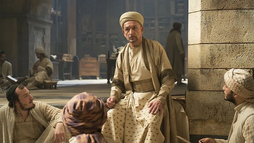 Ben Kingsley portrays Ibn Sina in The Physician movie, sitting and lecturing students in a historical 11th-century Persian library setting.
