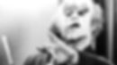 John Hurt as John Merrick in The Elephant Man, wearing distinctive prosthetics and gesturing emotionally in a classic black and white scene.