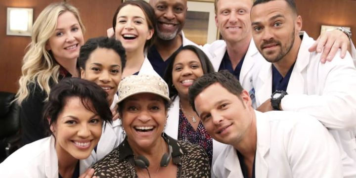 Grey's Anatomy cast smiling together, including Jesse Williams, Ellen Pompeo, Chandra Wilson, and James Pickens Jr.