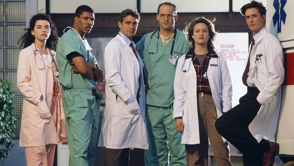 The original cast of ER, including George Clooney, Noah Wyle, and Julianna Margulies, standing together.