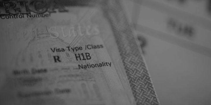 Close-up of a United States visa page showing the “H1B” visa classification and patterned security microprinting.