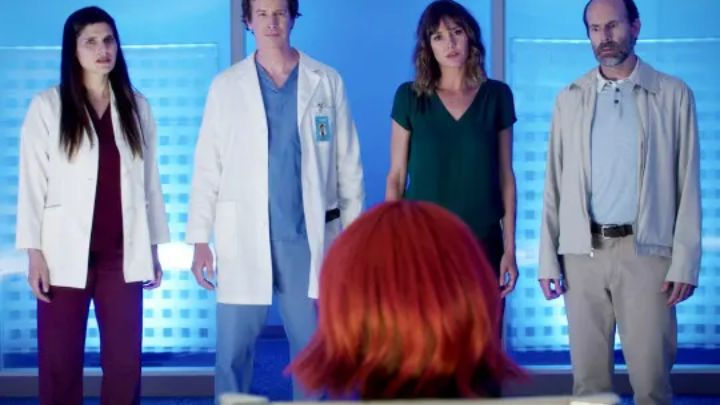 Lake Bell, Rob Huebel, Erinn Hayes, and Brian Huskey stand in a line facing a red-haired figure in a scene from the show Childrens Hospital.
