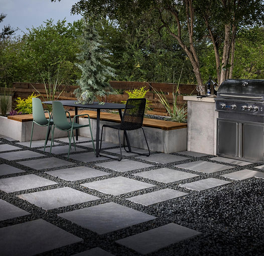 paver stepping stones, sitting wall, and outdoor kitchen