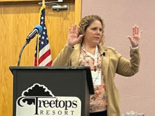 Linnea speaking at a conference this year