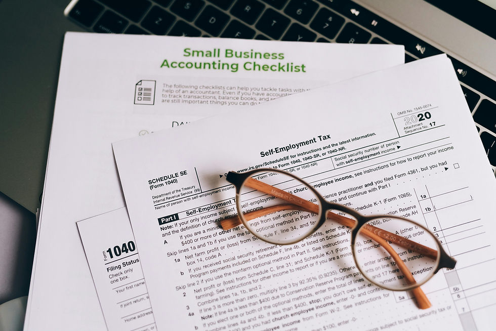 Glasses on tax forms labeled "Self-Employment Tax" and "Small Business Accounting Checklist" on a laptop keyboard. Representing Matthew Schissler's analysis of small business funding.
