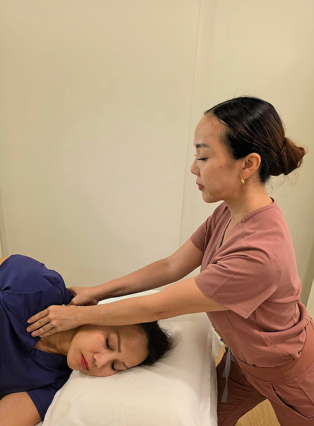Professional therapist applying targeted pressure to client's shoulder to relieve chronic pain and tension