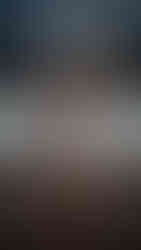 Fire performer outside a building holding fire fans posting for the camera