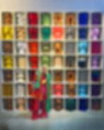 interior designer wearing a colourful outfit standing in front of a display of colourful furniture