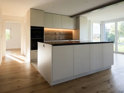 Küche in Farbe Champagner, mit Kochinsel und Rückwand in Holzoptik
