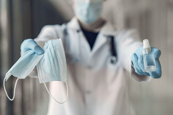 Download Doctor Hold The Antiseptic And Masks In His Hand for free.jpeg