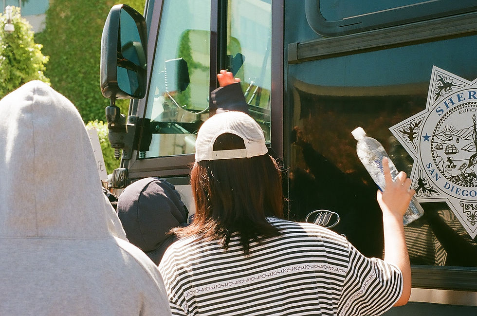 Protesters bang on the side of the buses carrying arrested protesters.