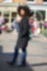 Black person with natural hair looking somber while walking with other people in the background.